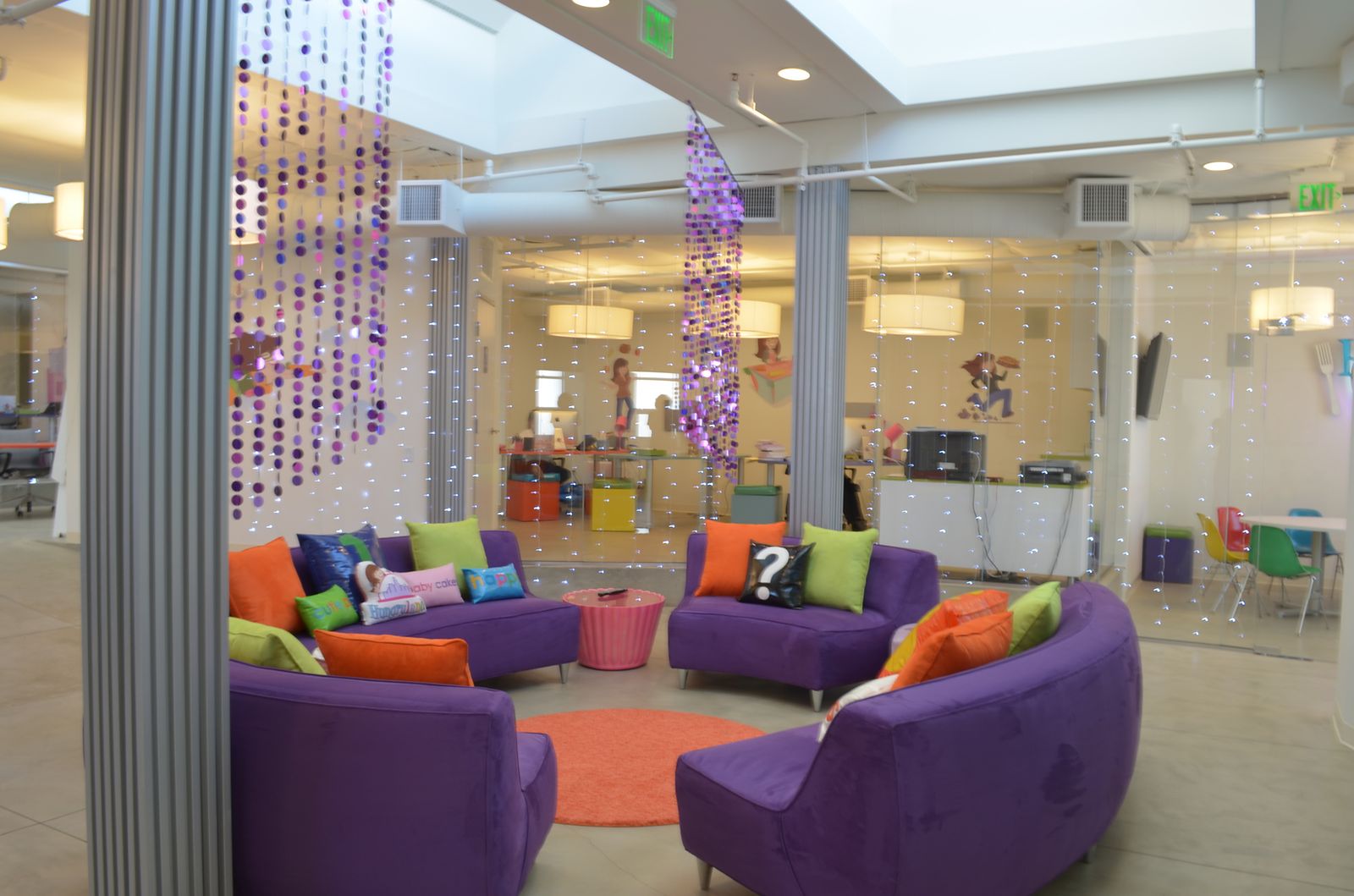 Creative office interior with skylights, glass partitions and purple lounge seating