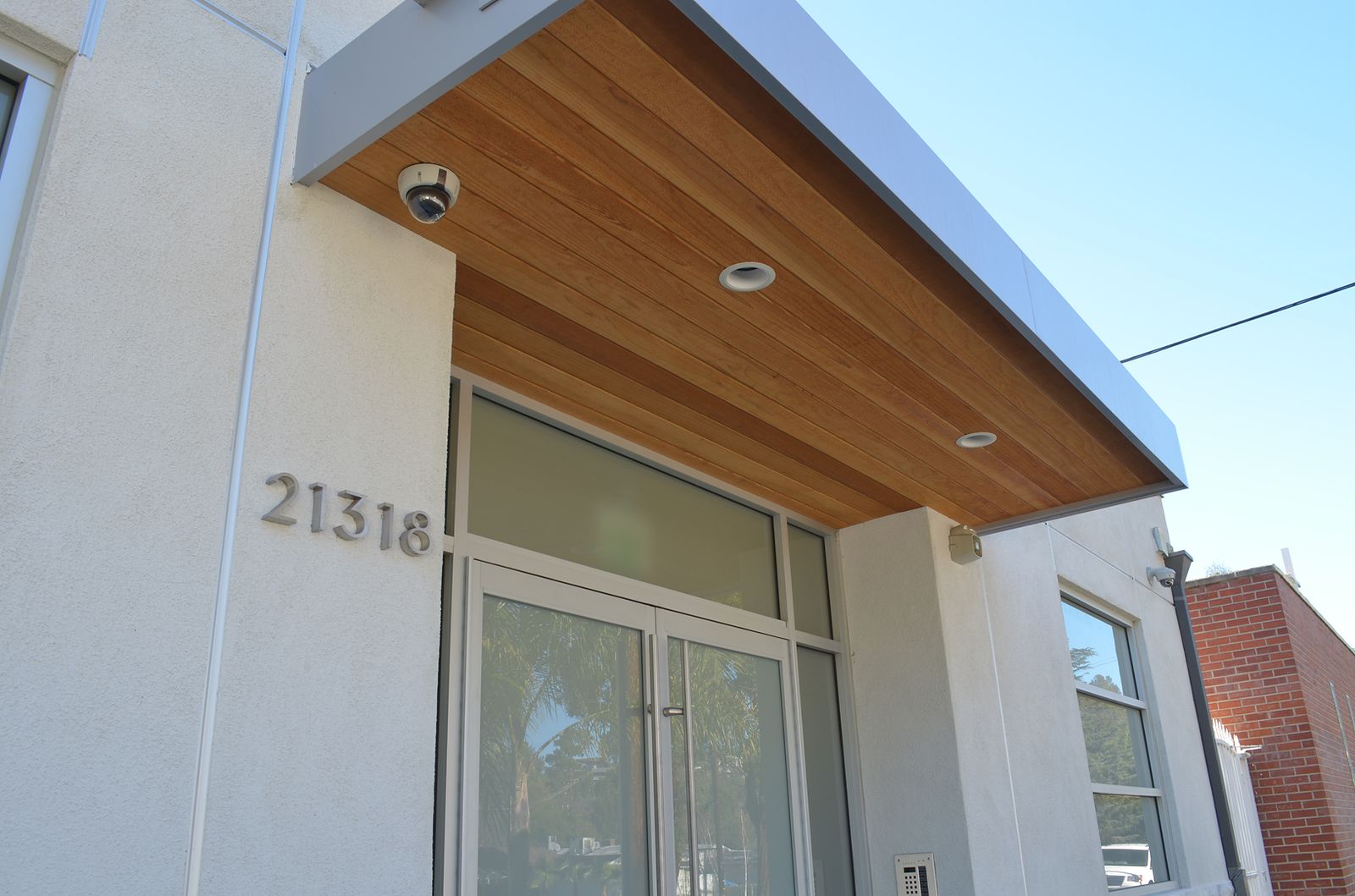Commercial entry canopy detail with cedar tongue-and-groove soffit, steel fascia and recessed lighting